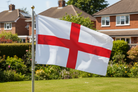 English flag waving in a garden with houses in the background