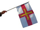 Flag with a red cross on a white background held by a person